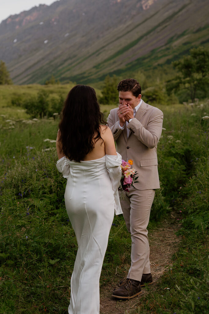 Intimate first look between bride and groom in the mountains during a summer Alaska elopement