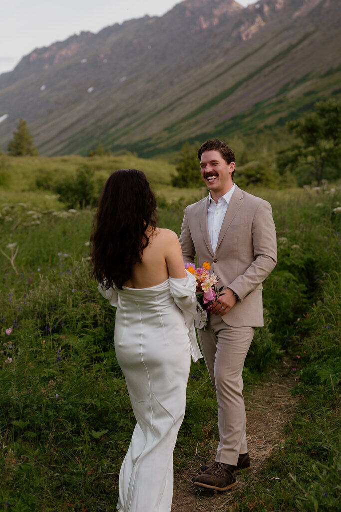 Intimate first look between bride and groom in the mountains during a summer Alaska elopement