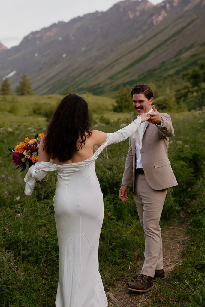 Intimate first look between bride and groom in the mountains during a summer Alaska elopement