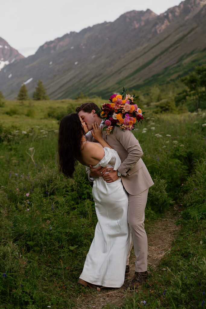 Couple sharing a quiet moment surrounded by wildflowers in the Alaska mountains