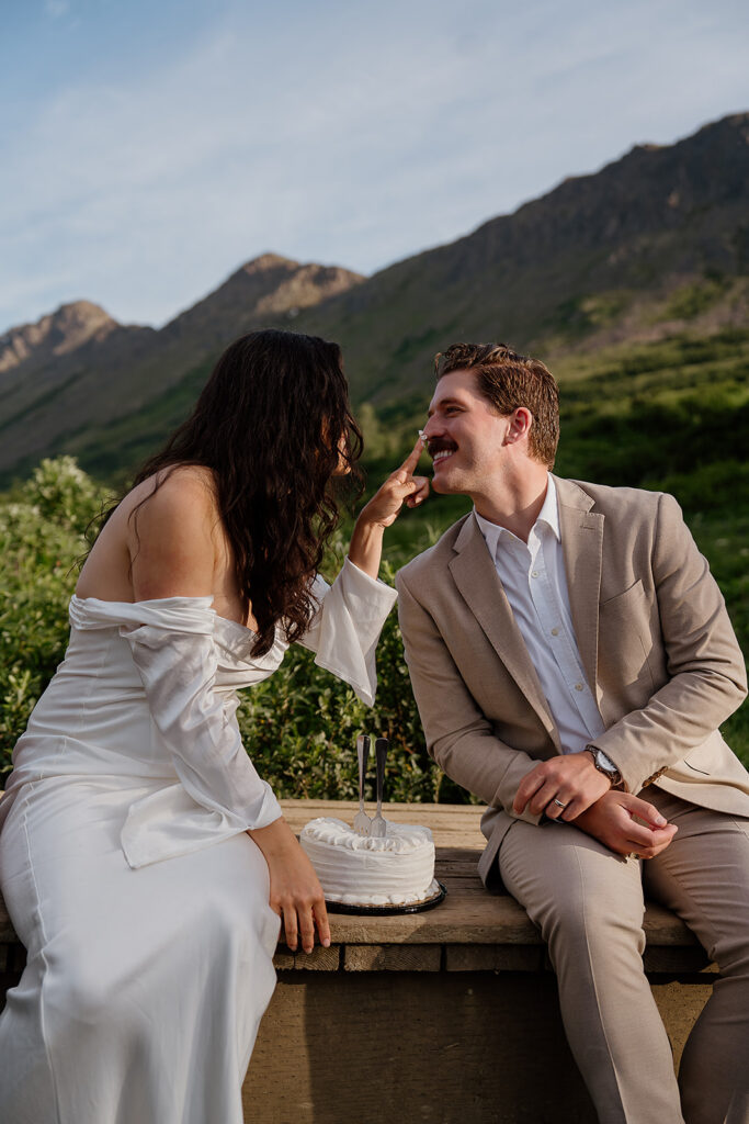 Couple cutting a small cake outdoors during their intimate Alaska elopement celebration