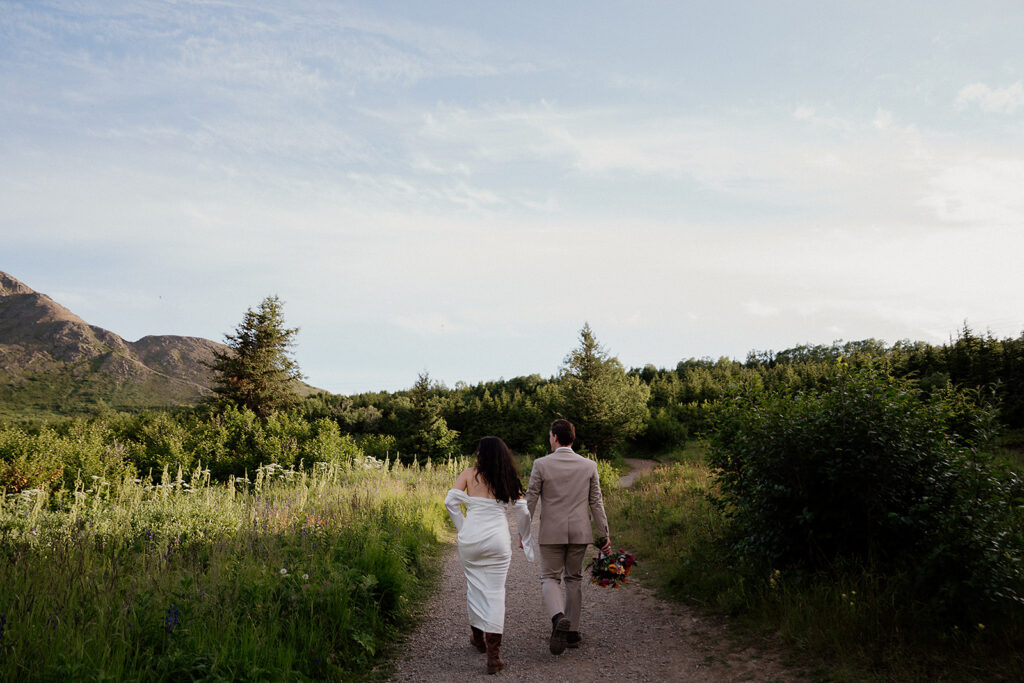 Wide landscape shot of couple in the distance with sweeping mountain views in Anchorage Alaska