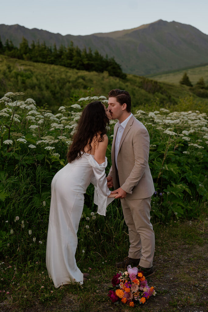 Couple sharing a quiet moment surrounded by wildflowers in the Alaska mountains