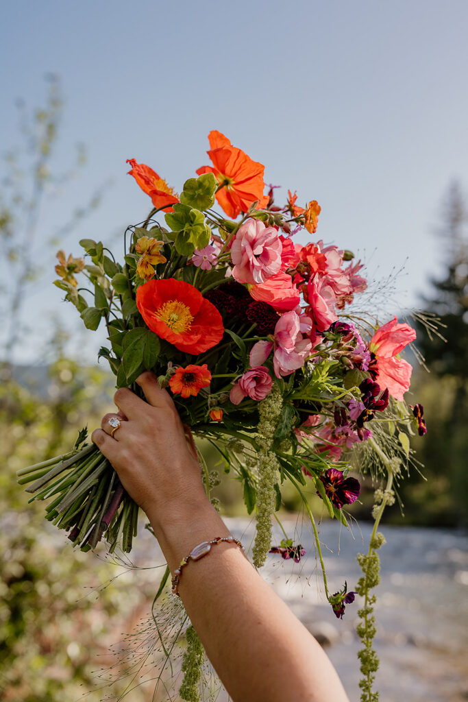 Newly engaged bride to be holds a colorful bouquet by Frolic Floral