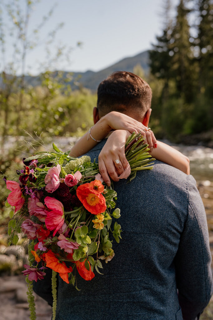 Newly engaged bride to be holds a colorful bouquet by Frolic Floral