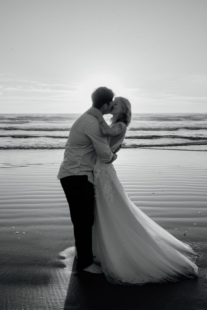 Couple kisses on Cannon Beach at sunset