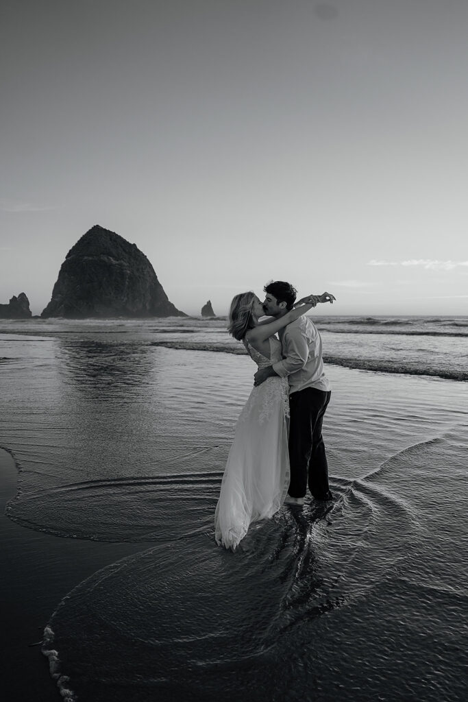 Couple kisses on Cannon Beach at sunset