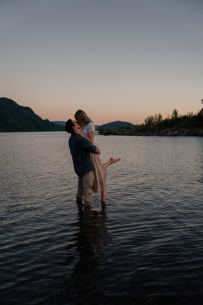 Couple standing in Yale Lake at blue hour during their engagement photos