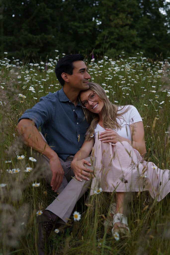 Couple sitting in a field of white wildflowers near Yale Lake in Washington