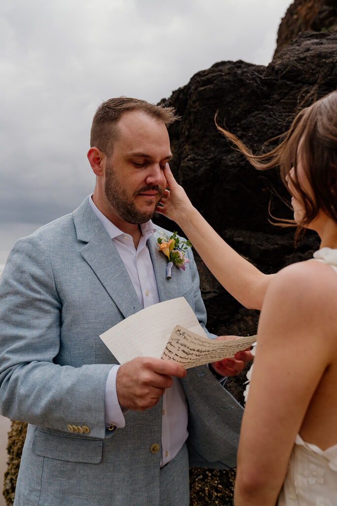 Emotional Arcadia Beach wedding ceremony with moody skies