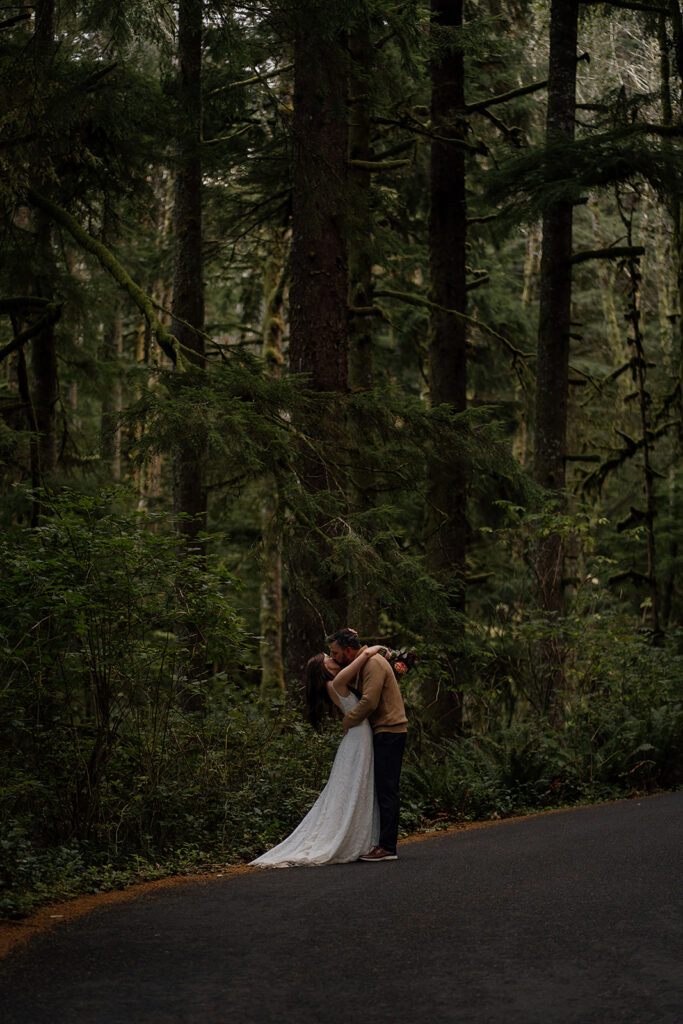 Bride and groom kiss in the forest in Ecola State Park