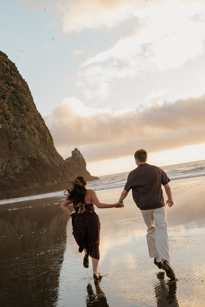 Couple runs on the beach after their surprise marriage proposal on the oregon coast
