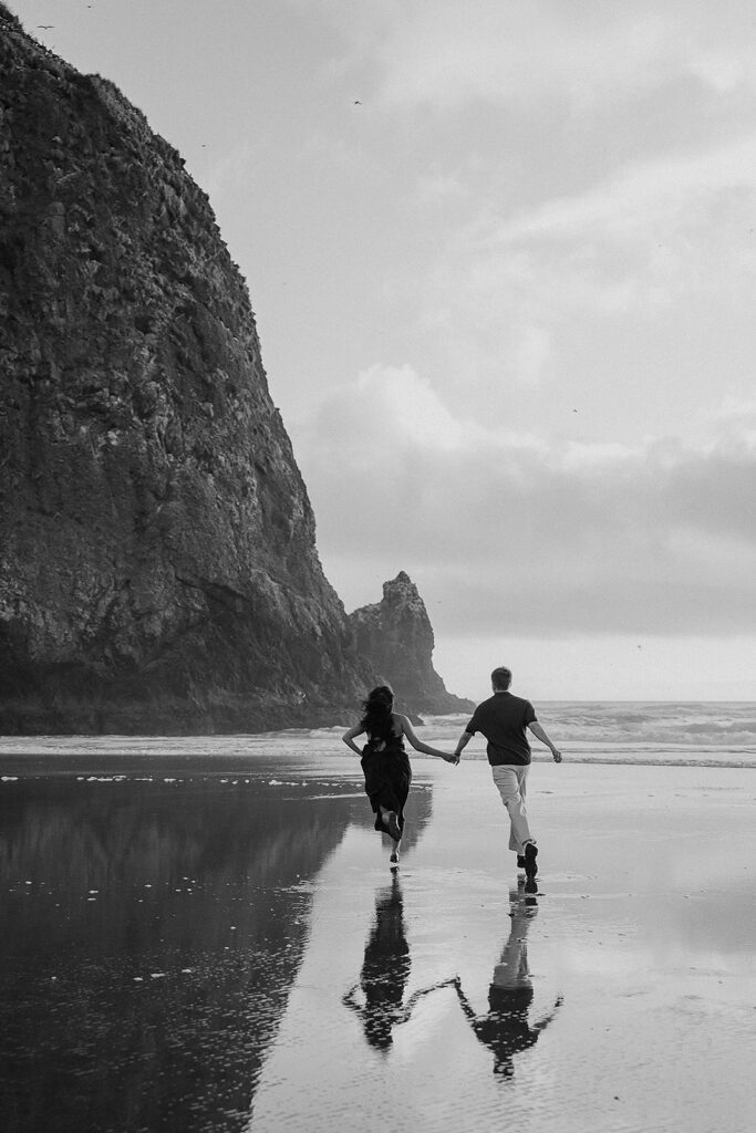 Couple runs on the beach after their surprise marriage proposal on the oregon coast