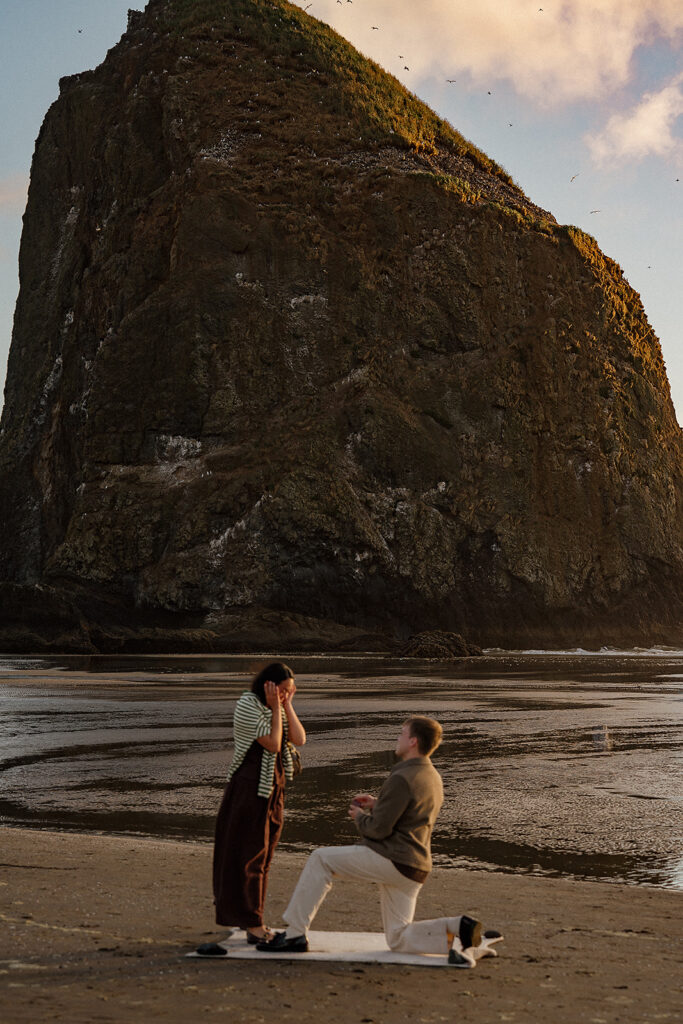 Surprise marriage proposal on Cannon Beach in front of Haystack Rock