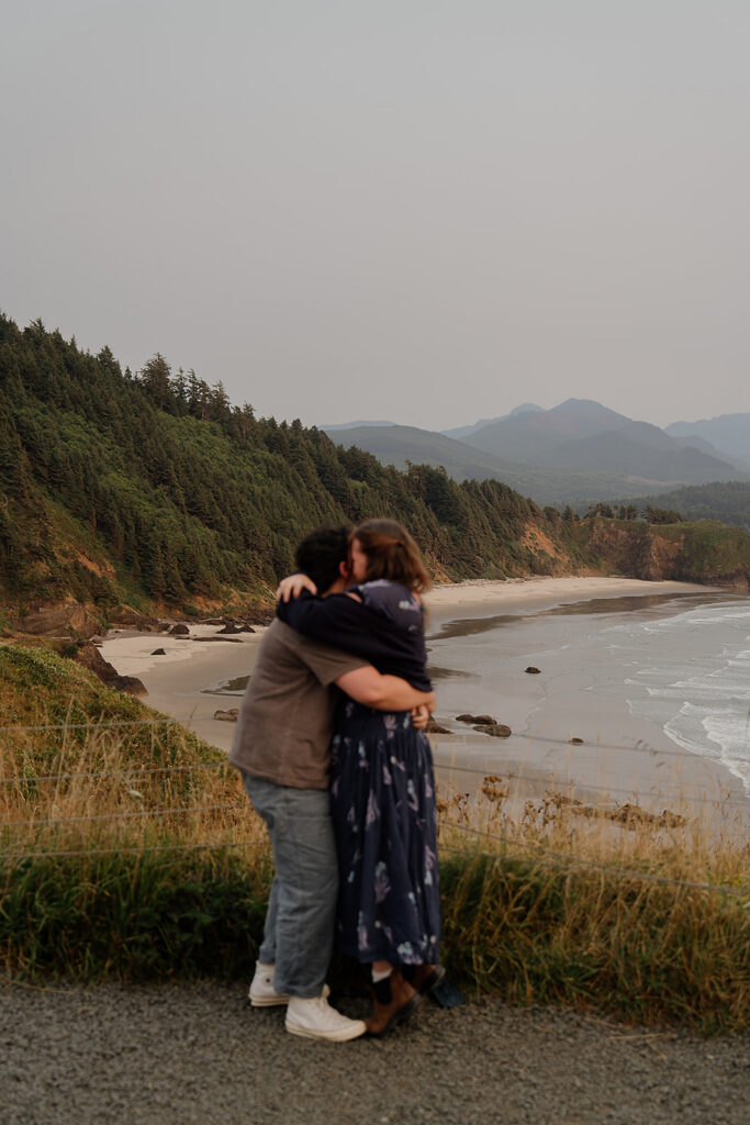 Couple hugs after a surprise proposal at Ecola State Park